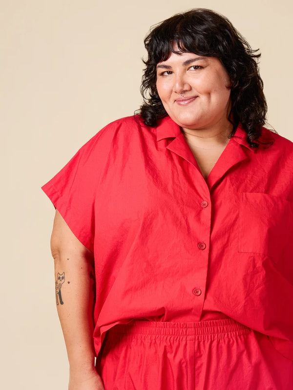 Person wearing a red outfit against a beige background