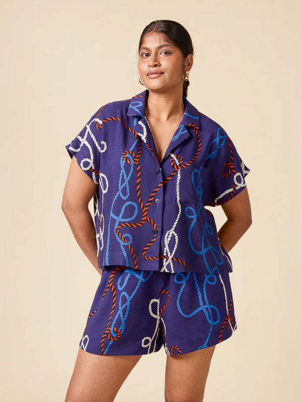 Woman wearing a blue patterned outfit on a beige background