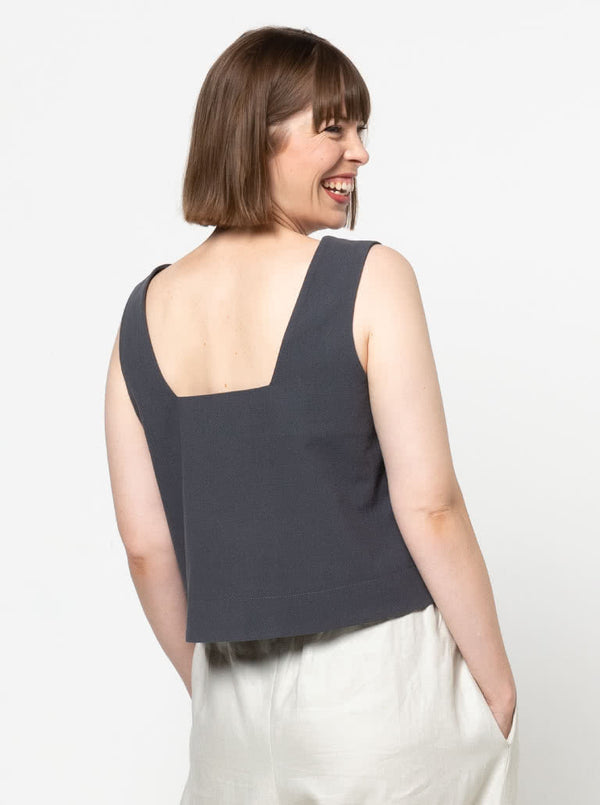 Image of the Byron Woven Top sewing pattern, highlighting the square neck, sleeveless design, and deep hem facing with topstitching, suitable for various elegant fabrics.