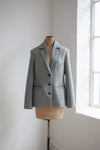 Gray blazer made using Naomi Blazer PDF Sewing Patternon a mannequin against a white wall with natural light.