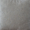 Striped pillow on a wooden chair against a plain wall