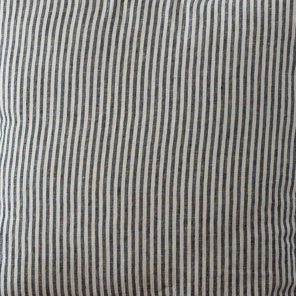 Striped pillow on a wooden chair against a plain wall