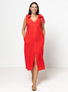 Woman wearing a red dress made using a style arc Esther woven dress sewing pattern with bow details on a white background