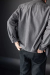 Person wearing a gray shirt and dark Elling Men’s Trouser against a dark background