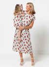 Woman and child wearing floral dresses against a white background
