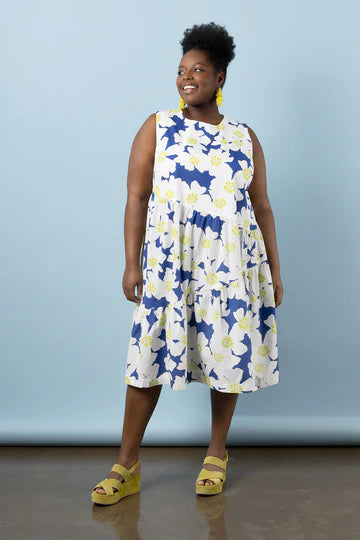 Woman wearing a floral dress made using Azure Dress, Skirt, and Top sewing pattern with a blue background