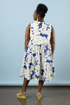 Woman wearing a floral dress made using Azure Dress, Skirt, and Top sewing pattern with a blue background