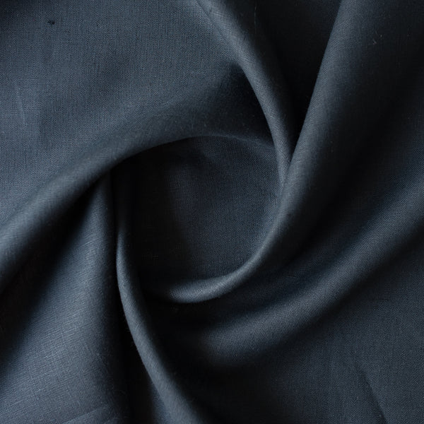 Close-up of darknavy blue linen fabric with folds