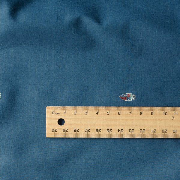 Blue Heritage Emblem Giza Cotton Blend Fabric with small embroidered logos on deep blue background