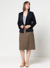 Woman wearing a navy blazer made using the Bronnie Tuxedo Jacket Sewing patternand brown skirt against a white background
