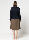 Person wearing a navy blazer made using the Bronnie Tuxedo Jacket Sewing patternand brown skirt on a white background