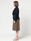 Woman wearing a navy blazer made using the Bronnie Tuxedo Jacket Sewing patternand brown skirt against a white background