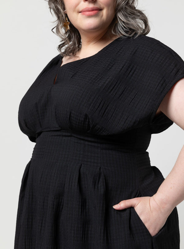 Person wearing a black dress made using Bronte Woven Dress sewing patternagainst a plain background