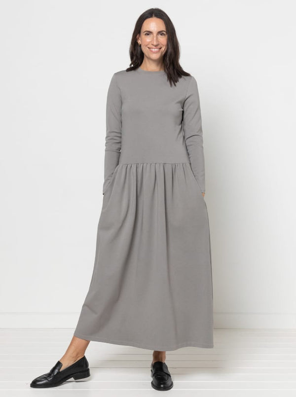 Woman wearing a gray Carter Dress made using StyleArc pattern with tee bodice and mid-calf linen skirt against a white background