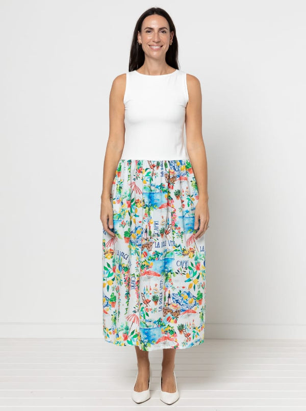 Woman wearing a white sleeveless top and colorful patterned skirt on a white background-Carter Dress made using StyleArc pattern with tee bodice and mid-calf linen skirt
