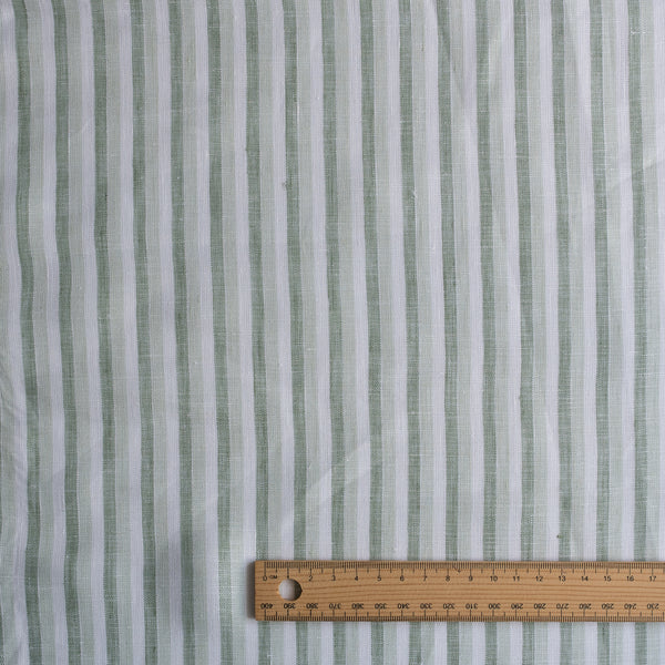 Coastal Sage Stripe linen fabric with soft sage-green and white yarn-dyed stripes, 100% linen, 130 GSM, 60 LEA with a ruler for scale on a white background