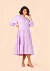 Woman wearing a light purple Poppy Dress against a beige background