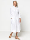 Woman wearing a white dress against a white backgroundThe dress is made from the Hampton Woven Dress Sewing Pattern – a mid-calf shirtdress with a gathered skirt, curved waist, sleeve or sleeveless options, and inseam pockets.