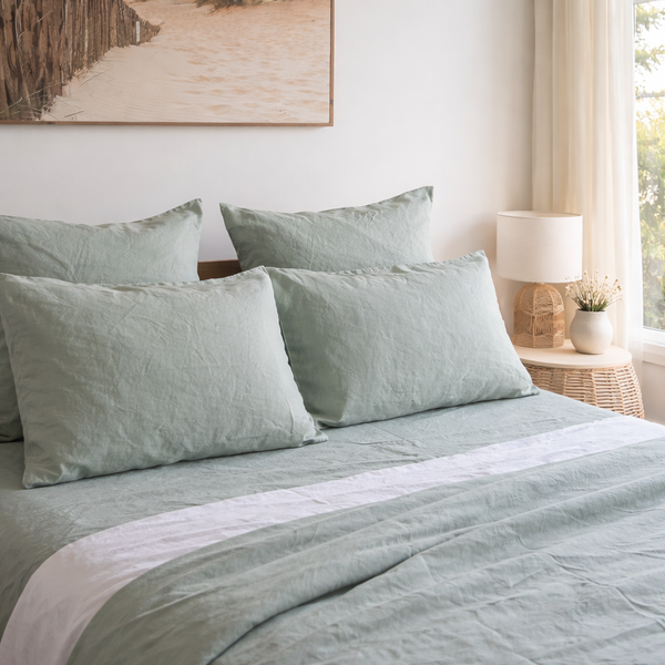 Bed with light Harbour Sage linen pillowcasesin a bedroom setting.