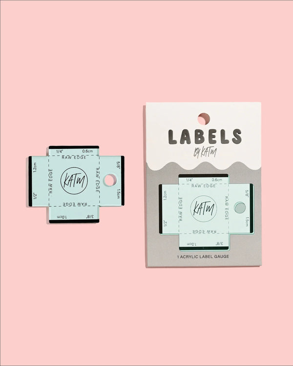 KATM labels and acrylic label gauge on a pink background
