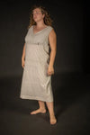 Woman wearing a sleeveless dressmade using The Lilian Sewing Pattern by Merchant & Millsagainst a black background