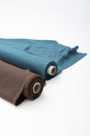 Steel Blue and Brown Linen Fabric Rolls on Pristine White Backdrop - de Linum Australia