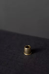 Small brass thimble on a dark textured surface