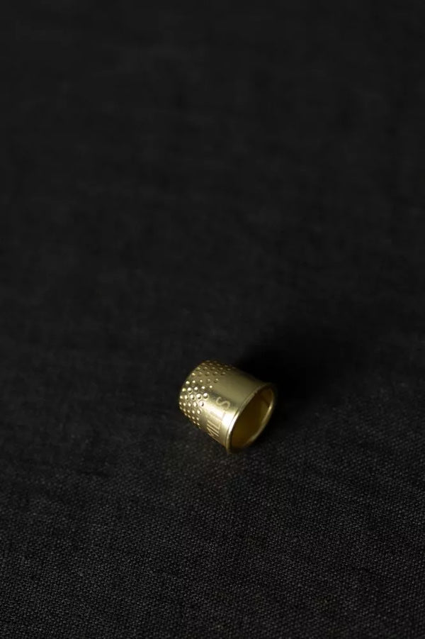 Gold thimble on a black background