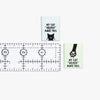 Two small signs with cat-themed text and a ruler for scale on a white background.