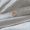 Close-up of beige fabric with a button, likely from a garment or textile product.