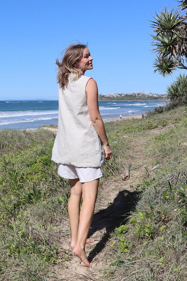 Pipit Vest Sewing Pattern - Reversible Oversized Vest in Two Lengths. woman wearing pipit vest made of natural colour linen fabric in the beach side