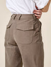 Brown pants with a white shirt on a beige background