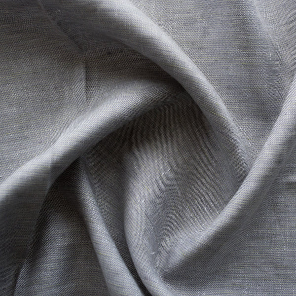Seamist 100% Linen Fabric with a unique denim-like twill weave in greenish-grey. Features purplish grey and green warp fibers with white weft fibers, perfect for sturdy garments like jackets, pants, structured dresses, and skirts. Soft, smooth hand, tight weave, and heavy drape.