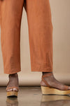 Brown pants made using Sepia Pants and Shorts sewing patternand sandals on a neutral background