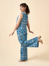 Woman wearing a blue geometric patterned pants made using Sepia Pants and Shorts sewing patternon a beige background