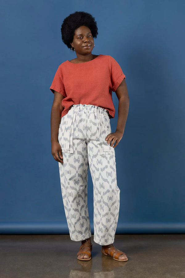 Woman wearing a red shirt and patterned pants made using Sepia Pants and Shorts sewing pattern against a blue background