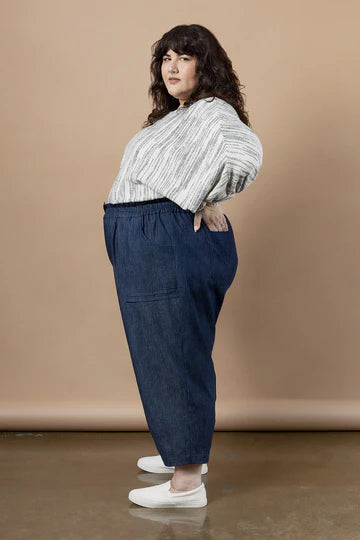 Woman wearing a striped shirt and blue pants made using Sepia Pants and Shorts sewing patternagainst a beige background