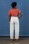 Person wearing a red top and white patterned pants made using Sepia Pants and Shorts sewing pattern against a blue background