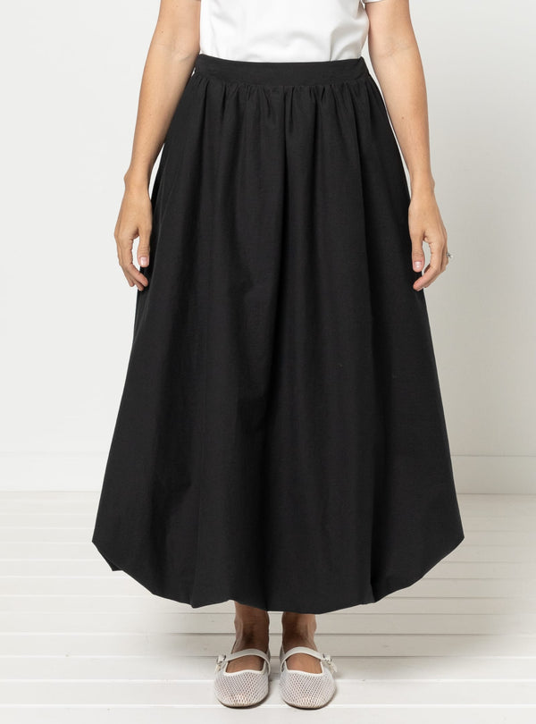 Person wearing a black skirtmade using Sophia Woven Bubble Skirt and Pant sewing pattern on a white background