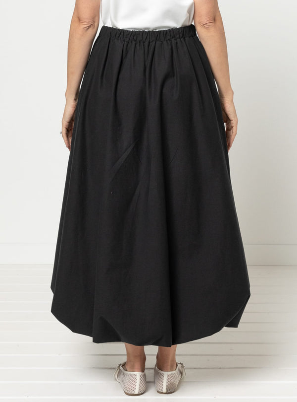 Person wearing a black skirt and white top made using Sophia Woven Bubble Skirt and Pant sewing pattern on a white background