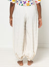 Person wearing white harem pants made using Sophia Woven Bubble Skirt and Pant sewing pattern and a colorful top on a white background