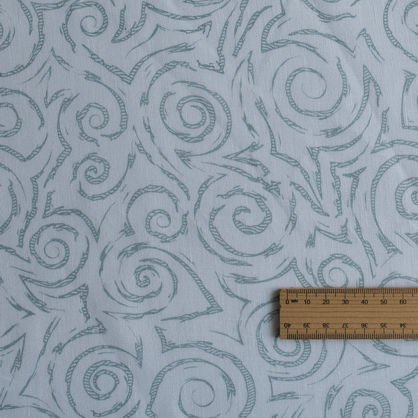 Textured fabric with spiral pattern and a wooden ruler for scale.