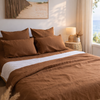 Bedroom with Tobacco Brown bedding and a lamp on a nightstand.