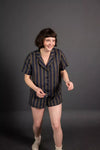 Person wearing a striped pajama set against a dark background