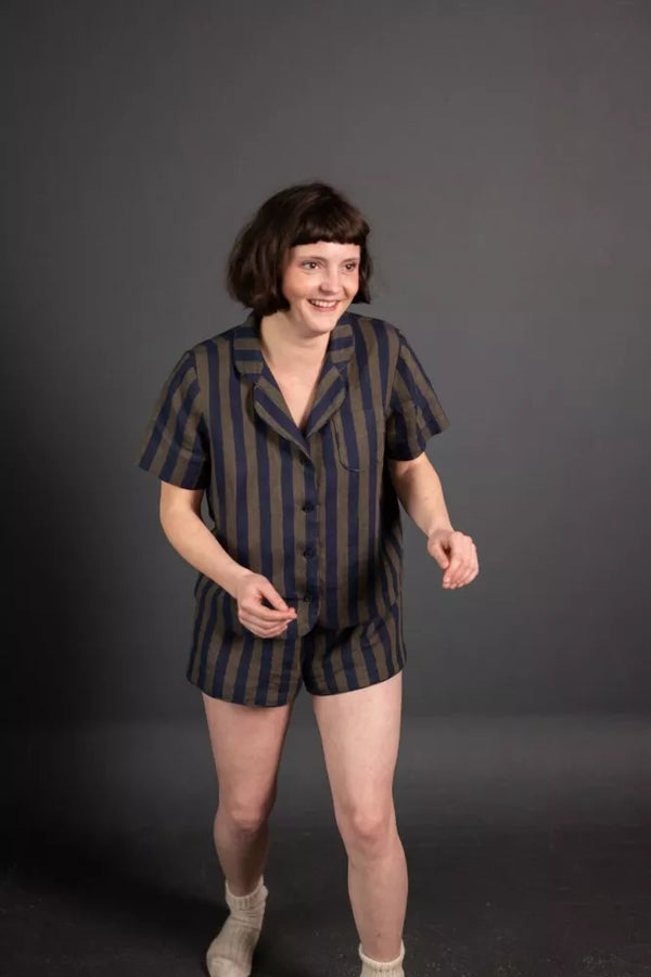 Person wearing a striped pajama set against a dark background
