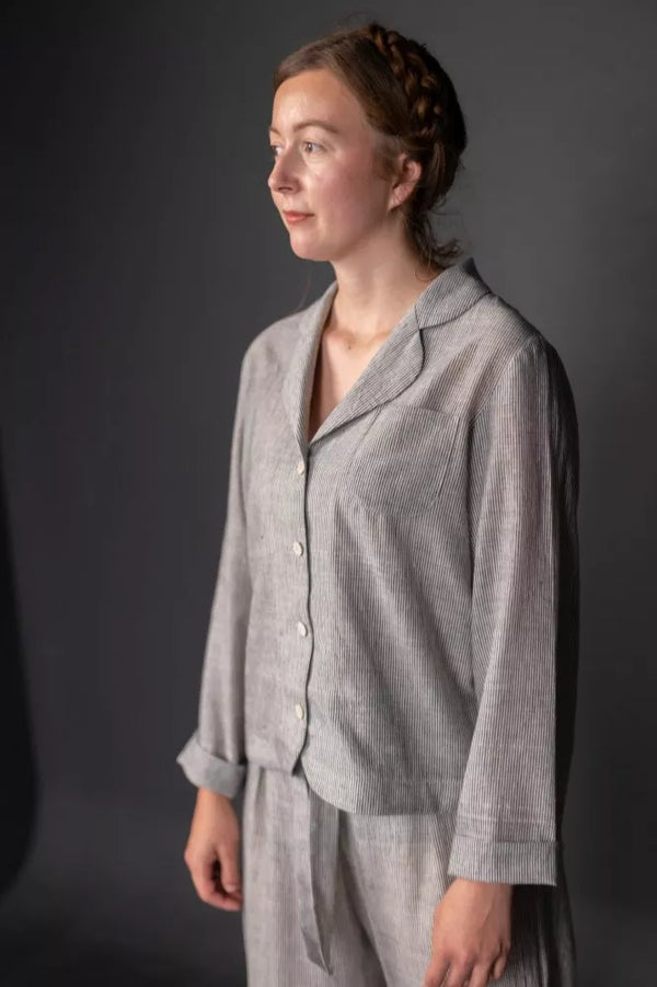 Woman wearing a gray outfit against a dark background