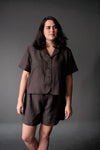 Woman wearing a brown outfit against a gray background