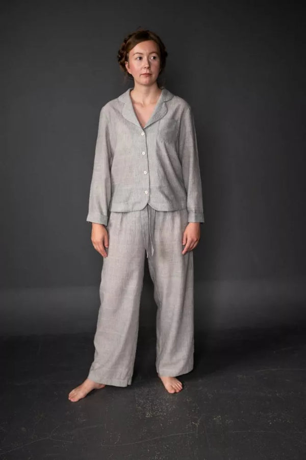Person wearing a gray winnie pajama set against a dark background