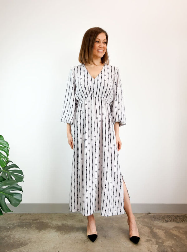 A fashionable Naomi woven dress sewing pattern with a V-neck, angled waist seam, and draw-string waist, ideal for an easy-fit, stylish garment.