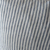 Striped blue and white pillow on a chair with a neutral background
